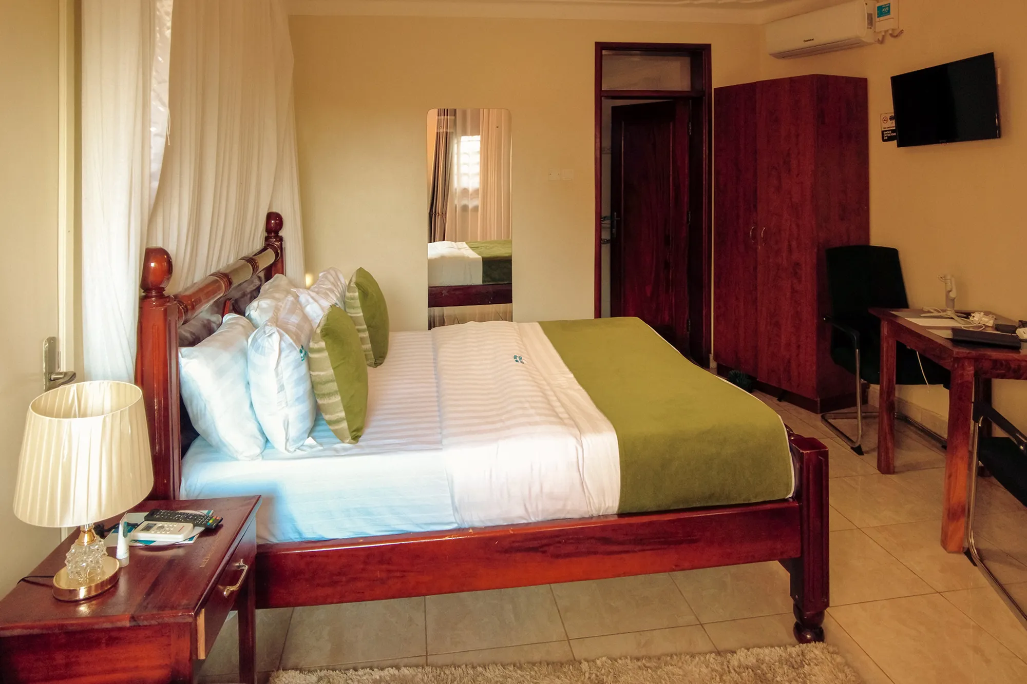 family room queen bed with wall tv, tea table and work table - close to the nile in Jinja